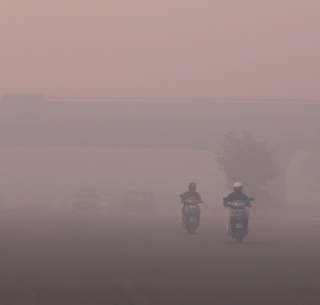 Commuters make their way amidst the heavy smog in New Delhi